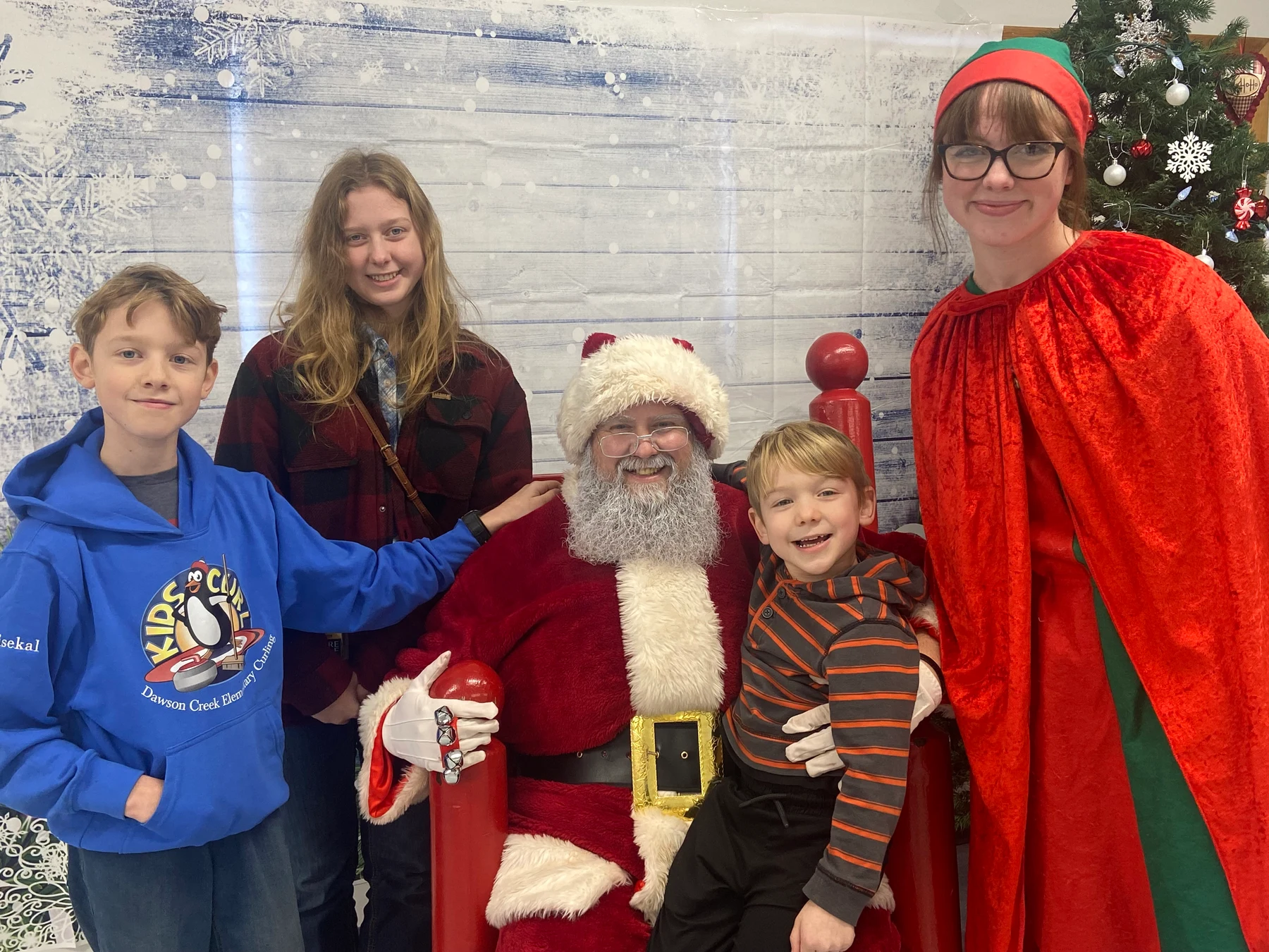 Santa Bryce smiling with his four children at a Christmas celebration